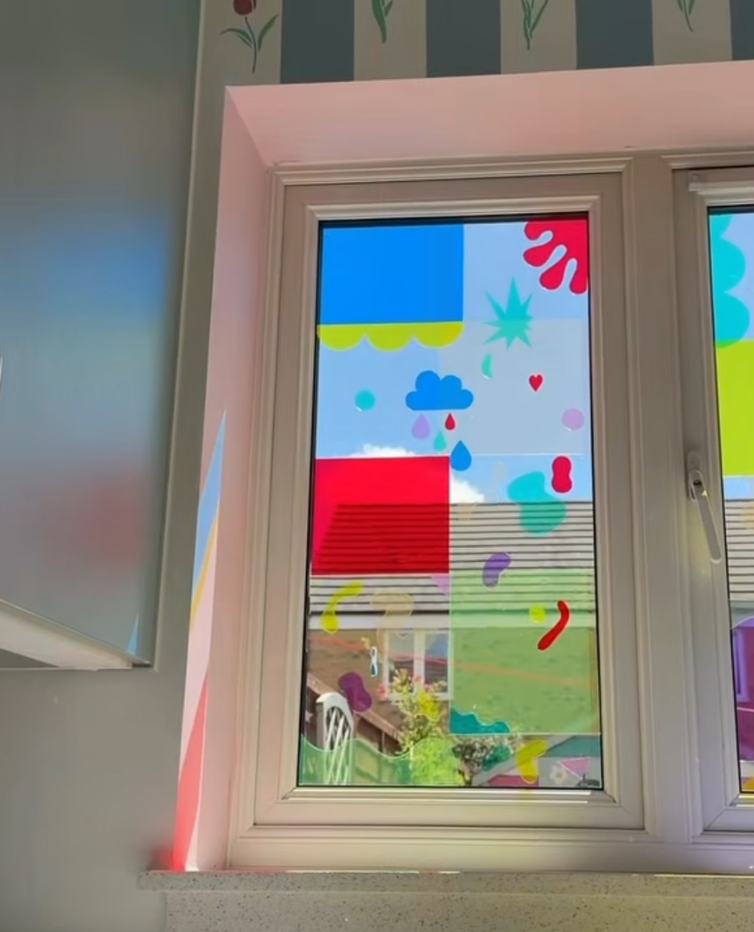 Colorful children’s artwork displayed on a window