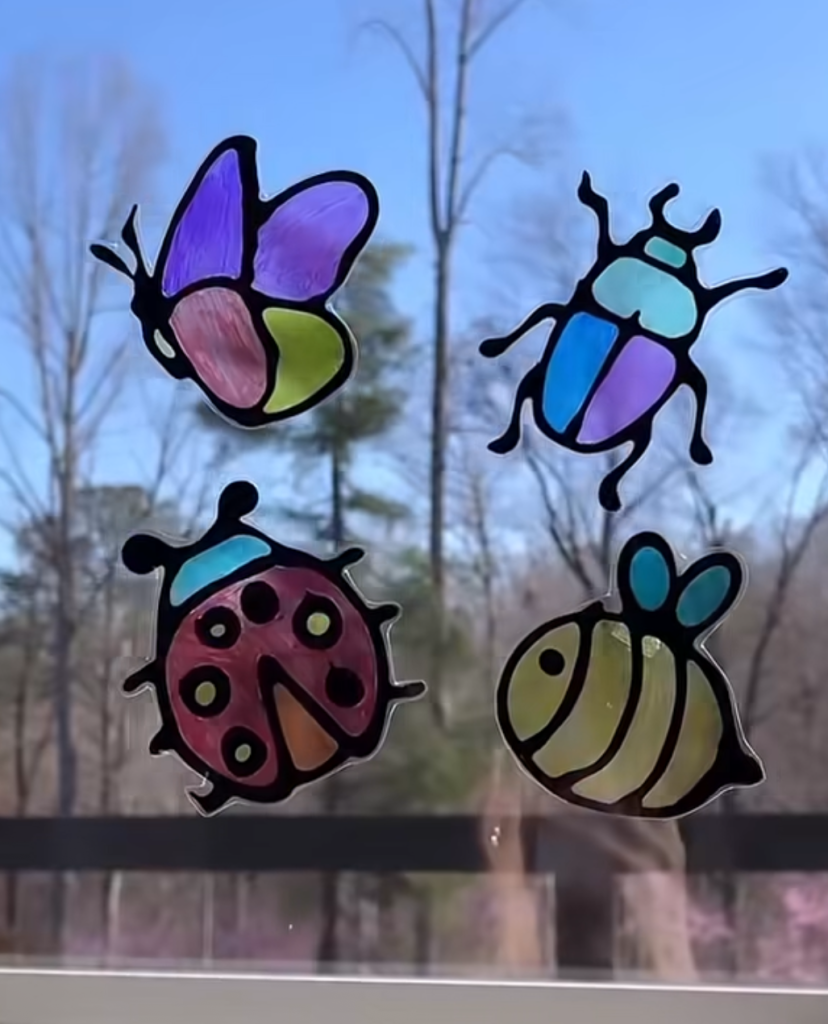 Colorful insect-shaped DIY suncatchers on a window